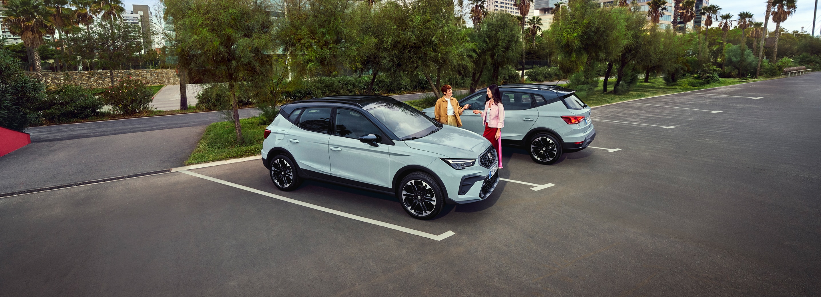 Two SEAT Arona cars parked outdoors in a sunny urban setting