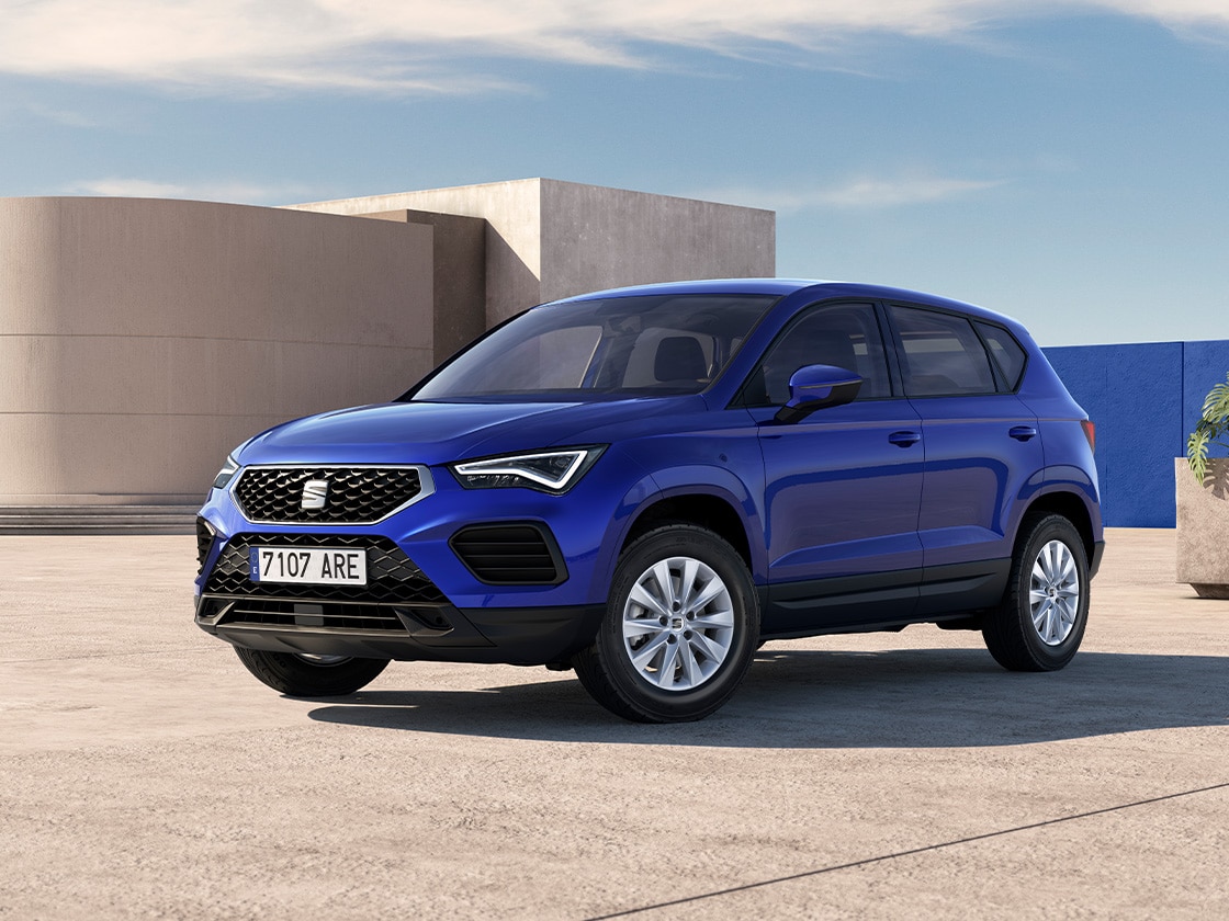 nose of a red seat ateca parked in a sunny spot. A woman is standing next to the car.