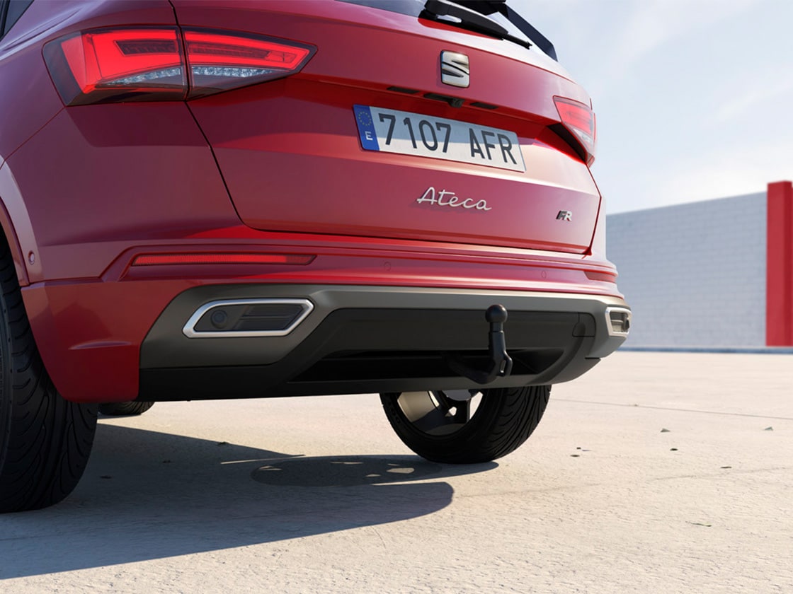 a woman walking away from a red seat ateca to showcase the peace of mind of enjoying seat care services.