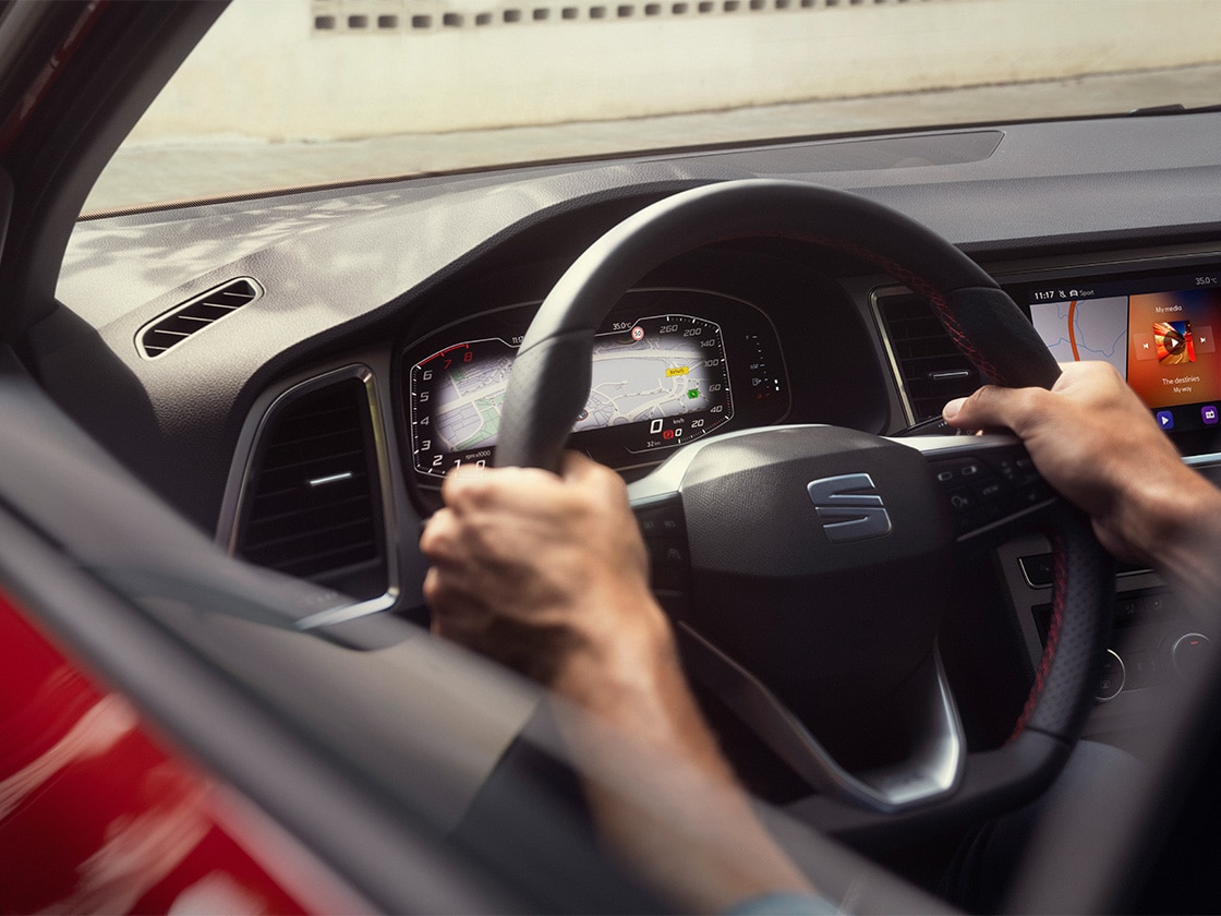 Interior view of the seat ateca that shows the steering wheel, to intend the peace of mind of driving safe while knowing that seat service mobility offers roadside assistance.