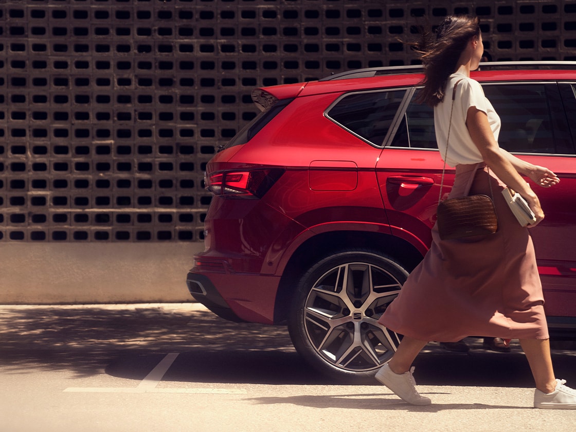 rear side view of the seat ateca parked in a sunny, urban spot.