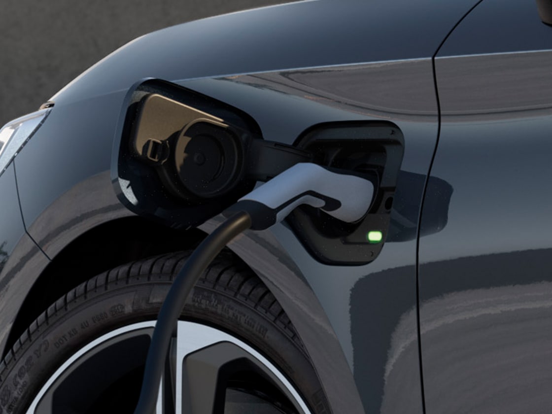 Hero angle of a manhattan grey SEAT Leon NF Sportstourer charging in parking outdoors.
