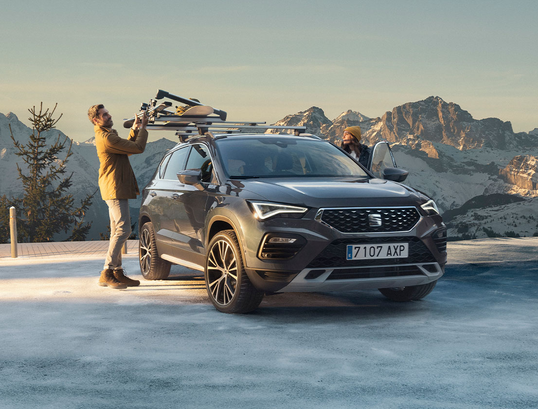 A man standing next to a Seat Ateca with snow rack accessory
