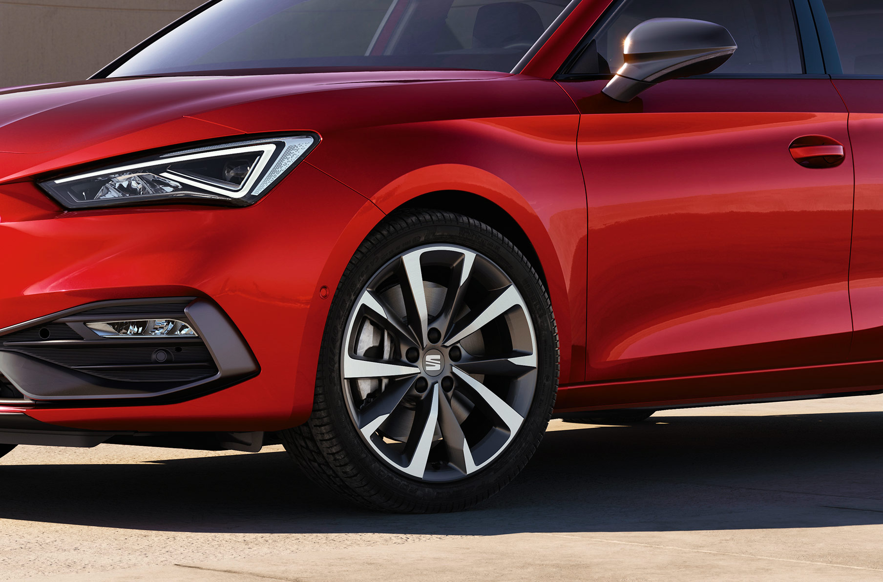 man standing next to seat leon desire red with performance alloy wheels