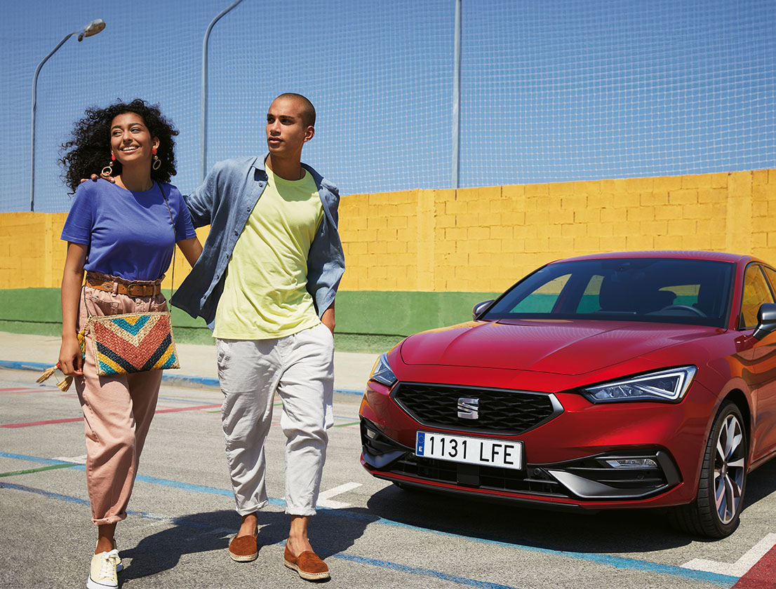 couple talking next to a seat leon desire red colour