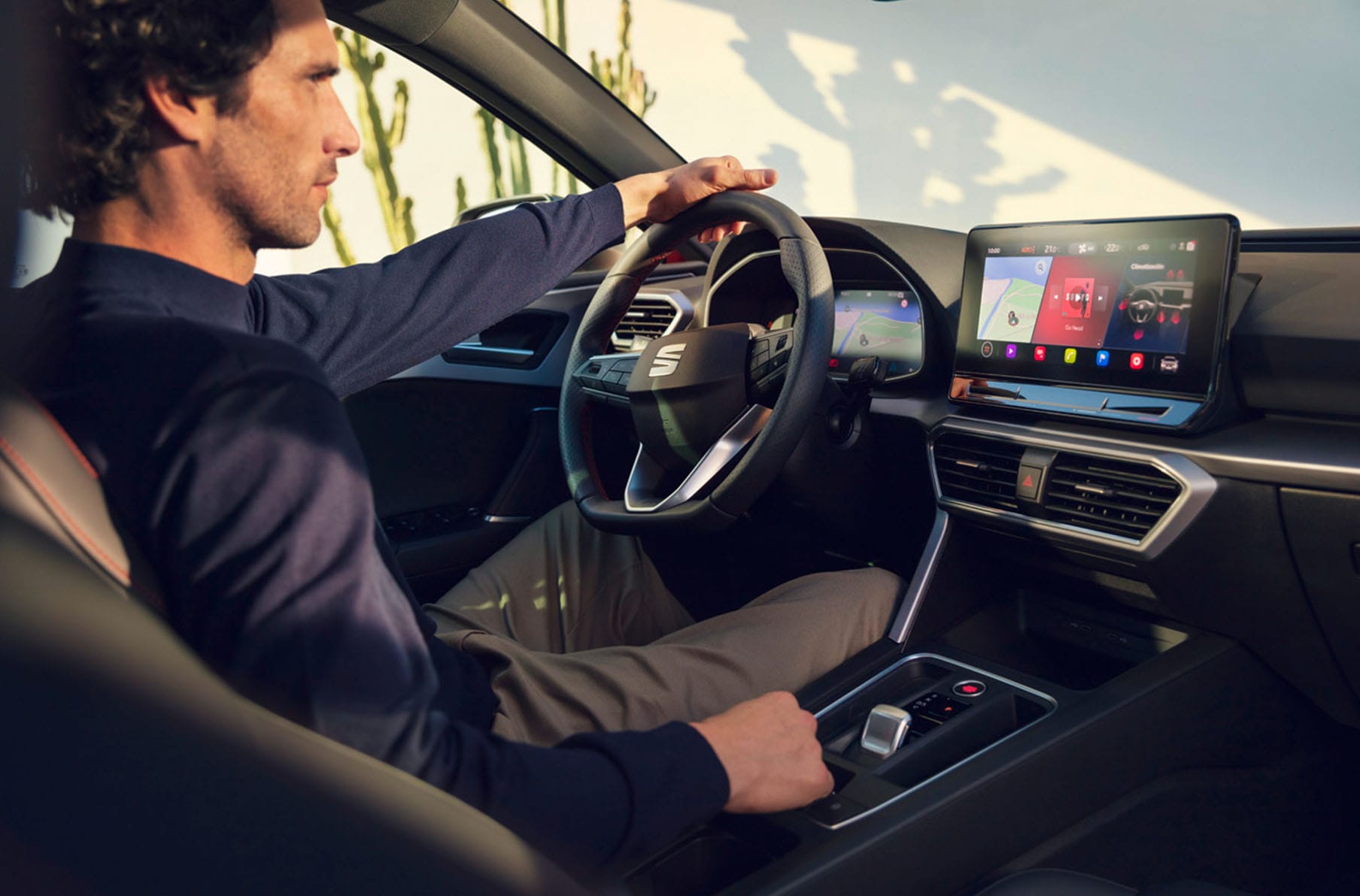  interior view of a man driving a seat leon using the dashboard