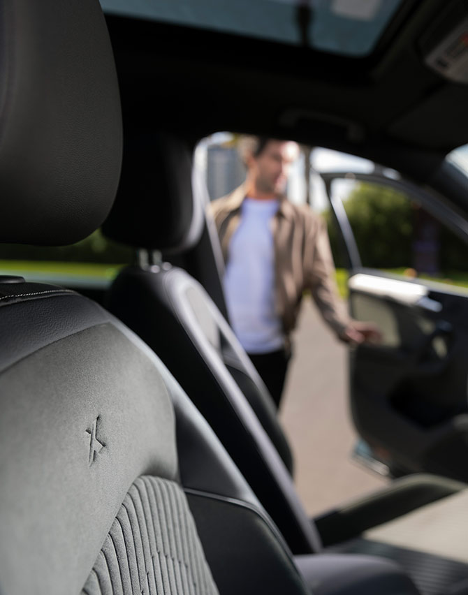 Interior view of a man opening a SEAT Tarraco XPERIENCE with upholstery seats 