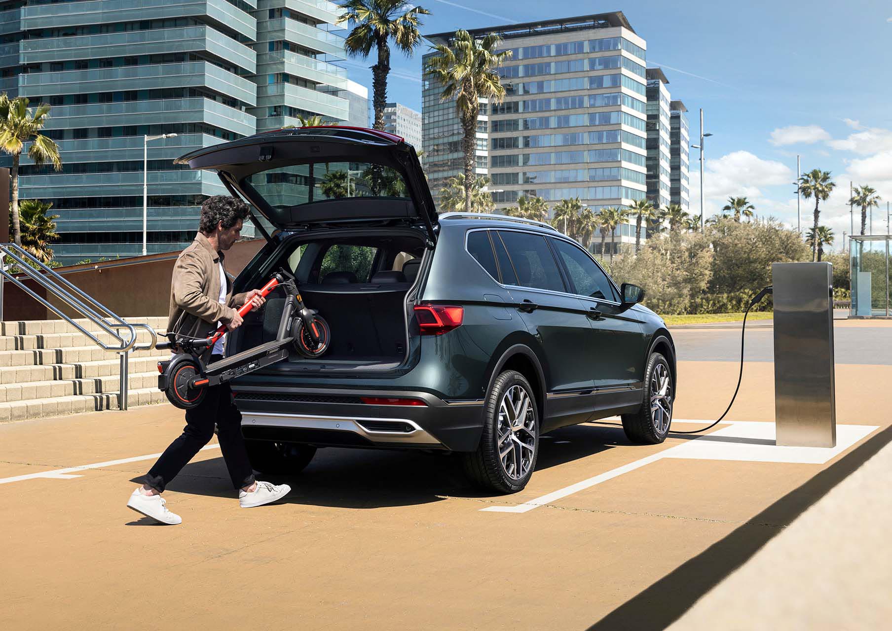 Man putting away a SEAT MÓ 65 inside the SEAT Tarraco XPERIENCE boot cabin  