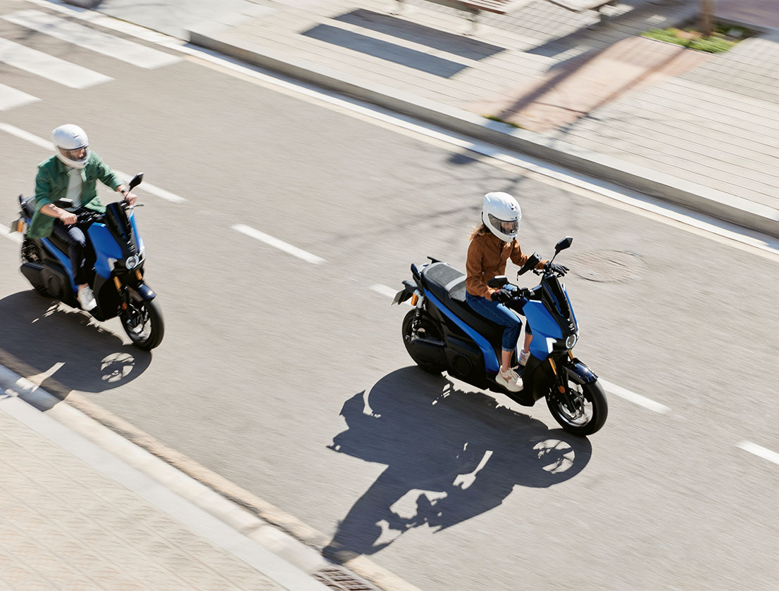 a couple driving their SEAT MÓ 125 performance on the street