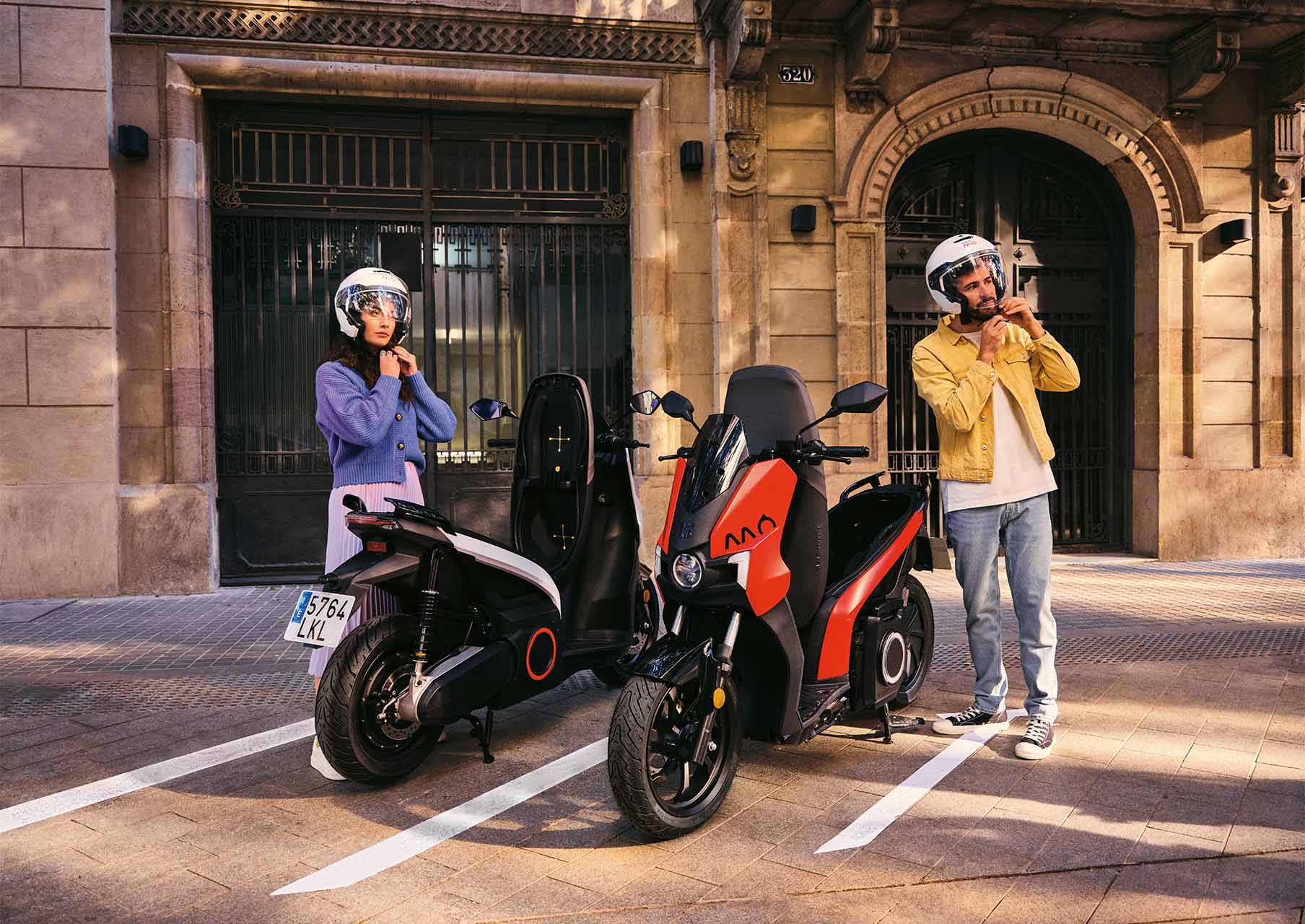 mann and woman putting on their scooter´s helmet in front of two SEAT MO 125