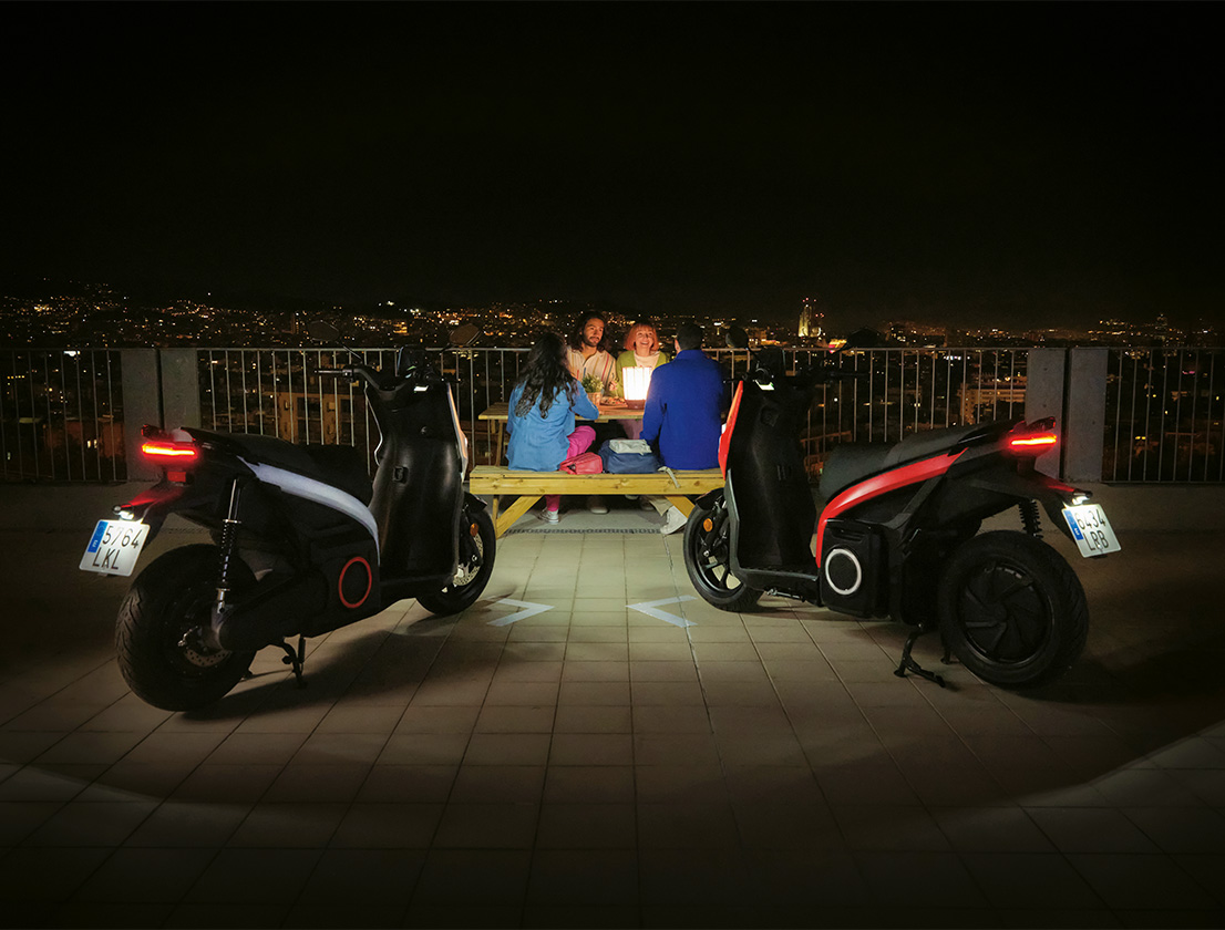  group of friends gathered at night at a viewpoint illuminated by the LED lights of two SEAT MO 125