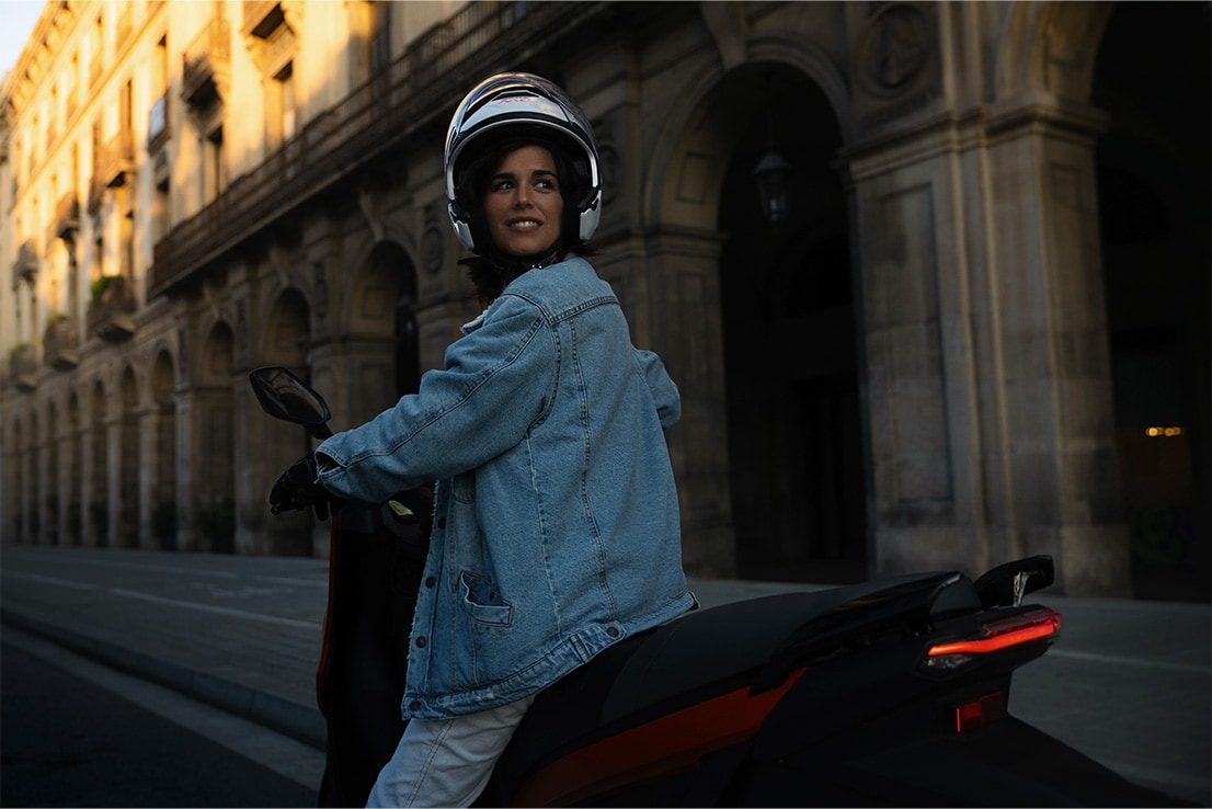 woman riding her SEAT MÓ 125 electric scooter with a top speed of 95 km per hour