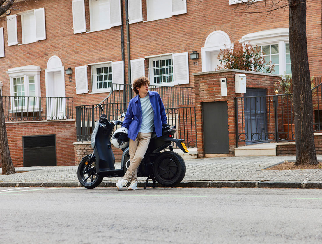 a man standing next to his SEAT MO 50 electric scooter