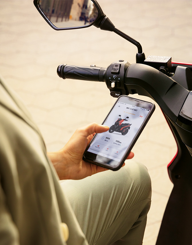 front view of a smartphone with the app keyless open to unlock a SEAT MO 125 electric scooter