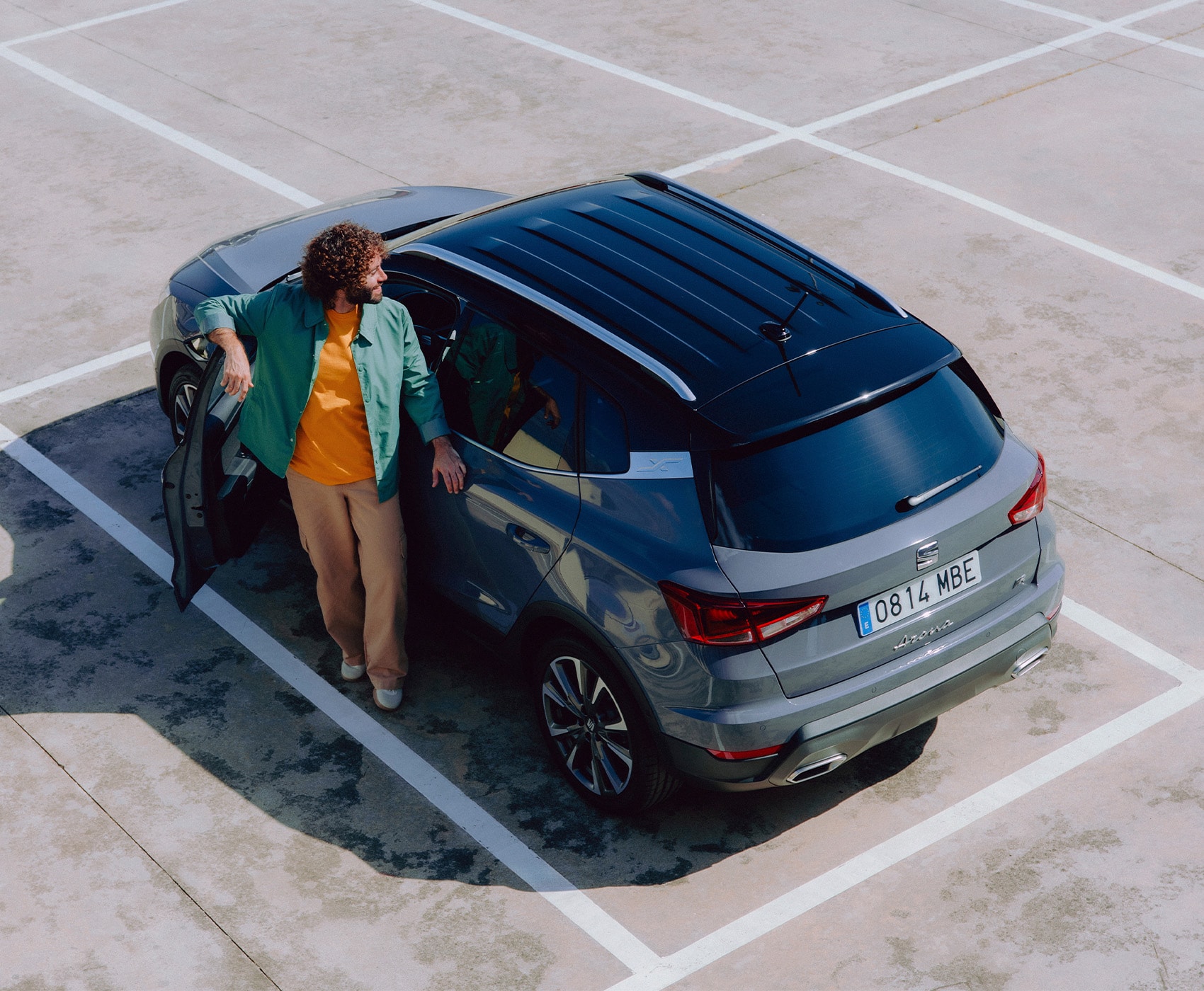 Top view of a SEAT Arona SUV parked in a car park with the front door open