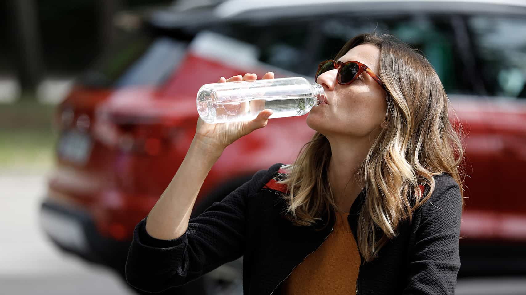 Woman drinking water SEAT Arona behind