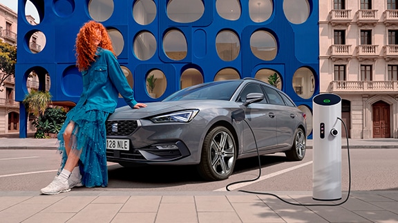 seat leon parked with a couple nearby, ready to debunk common myths about hybrid electric vehicles