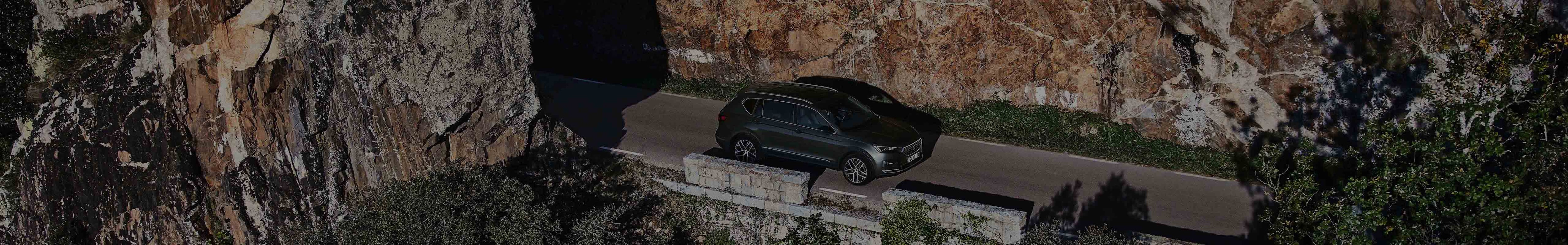 Drone view of the SEAT Tarraco XPERIENCE Dark Camouflage colour on a road mountain