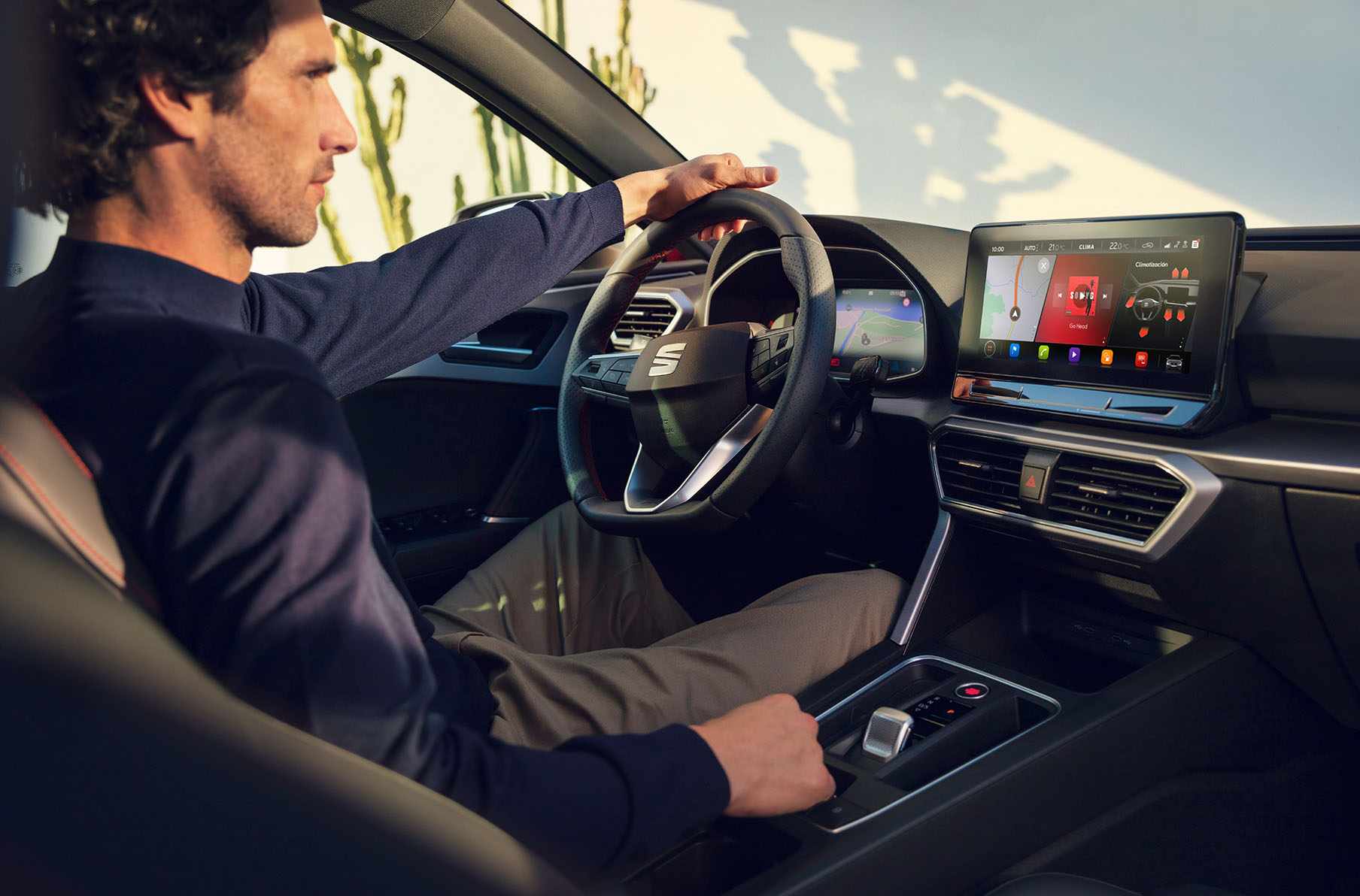  interior view of a man driving a seat leon using the dashboard