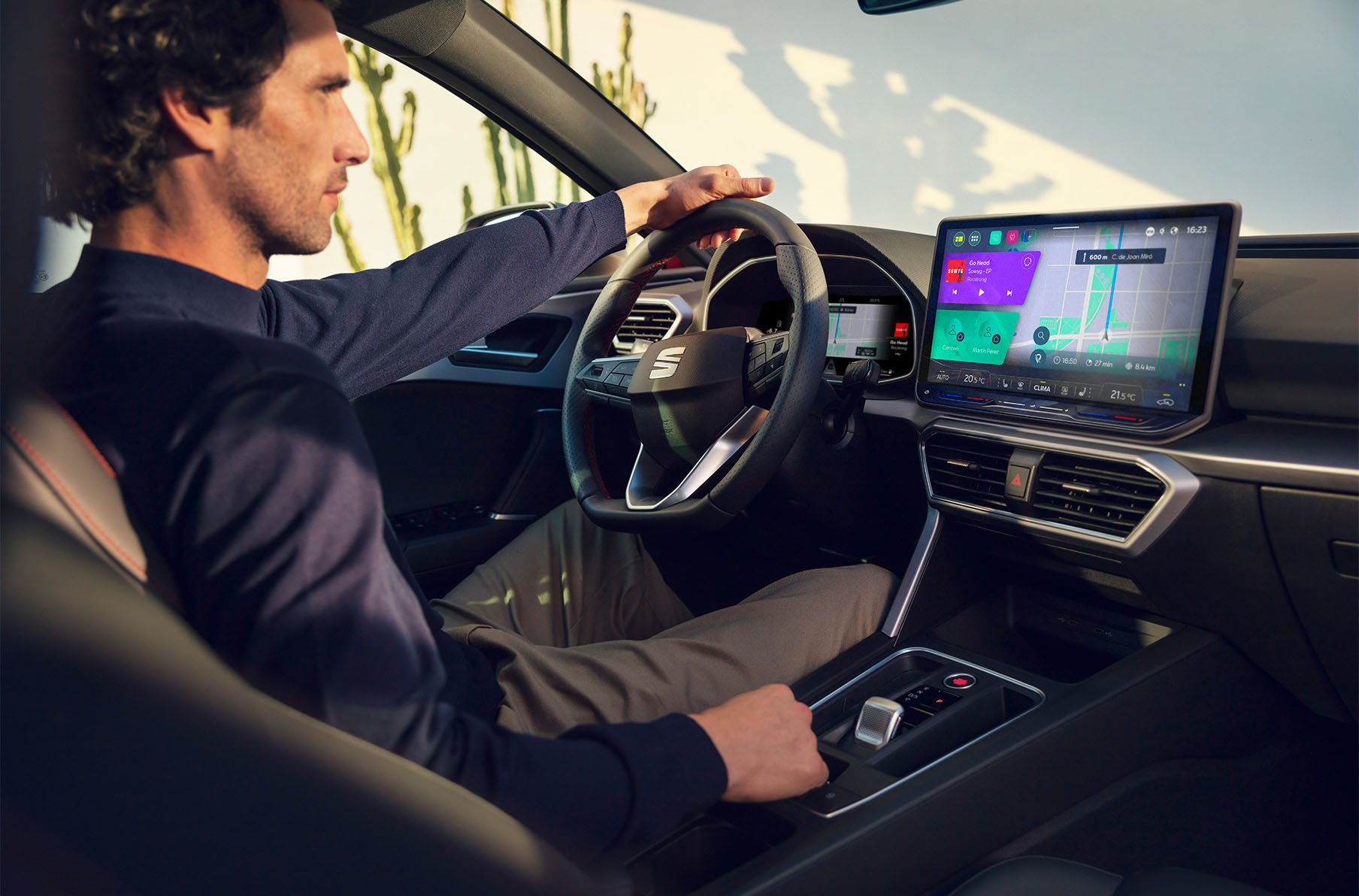  interior view of a man driving a seat leon using the dashboard