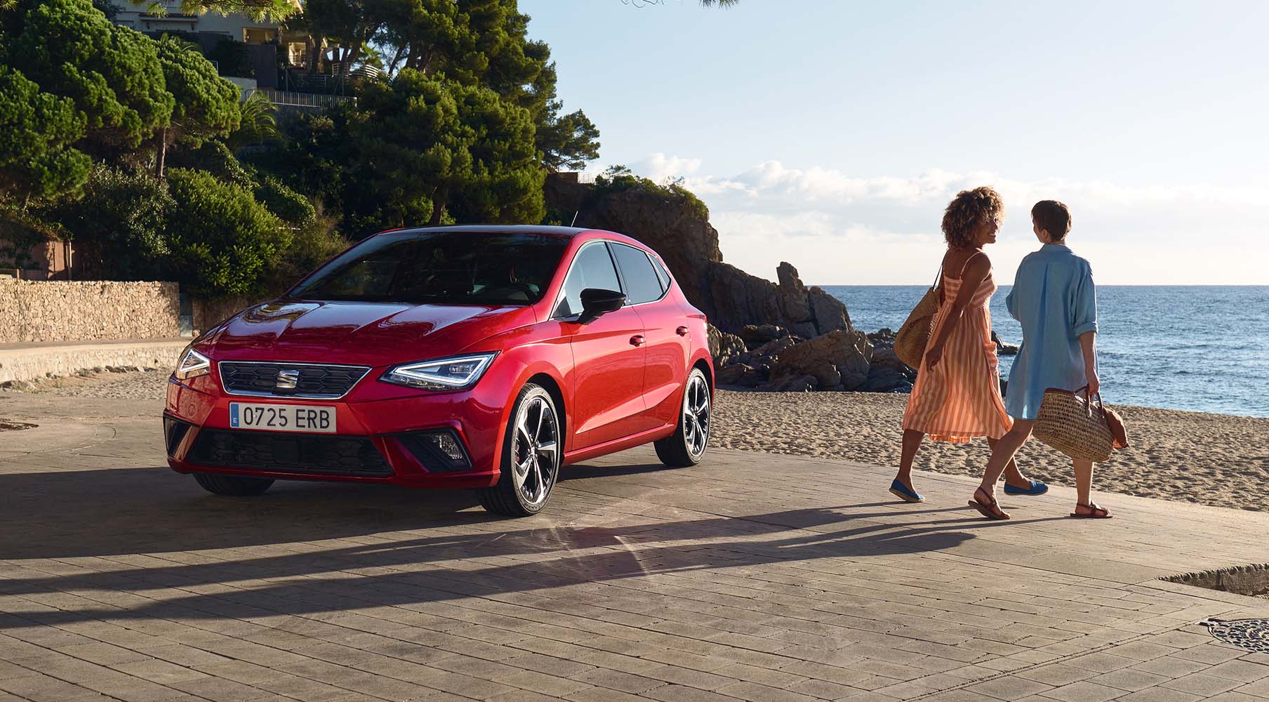 SEAT new car services maintenance end of life vehicles – Red SEAT Alhambra MPV 7 seater parked in countryside with grassy hills and a family standing beside