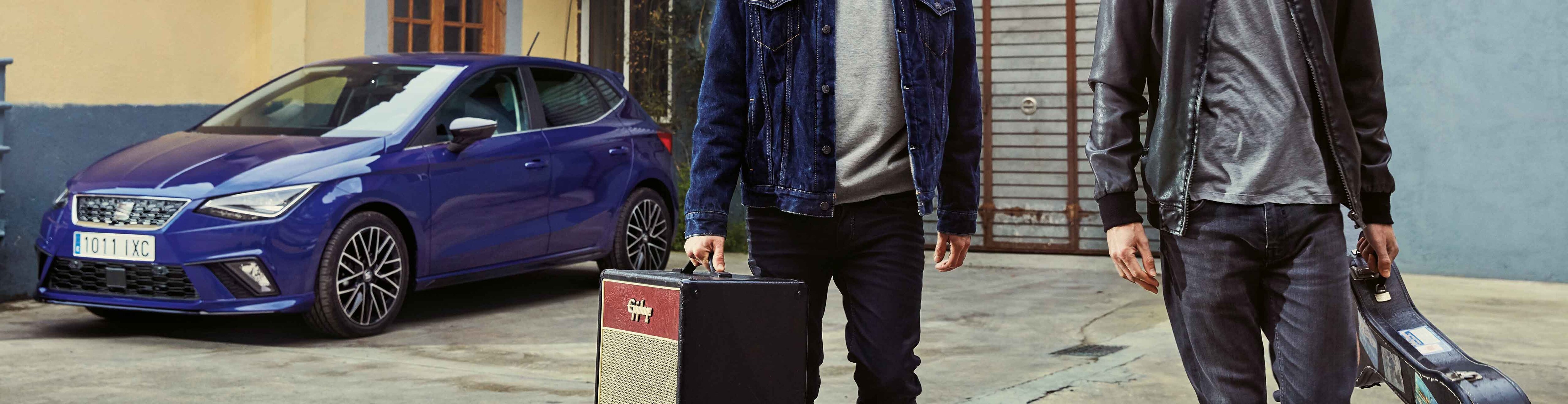 Two musicians walking away from the SEAT Leon 