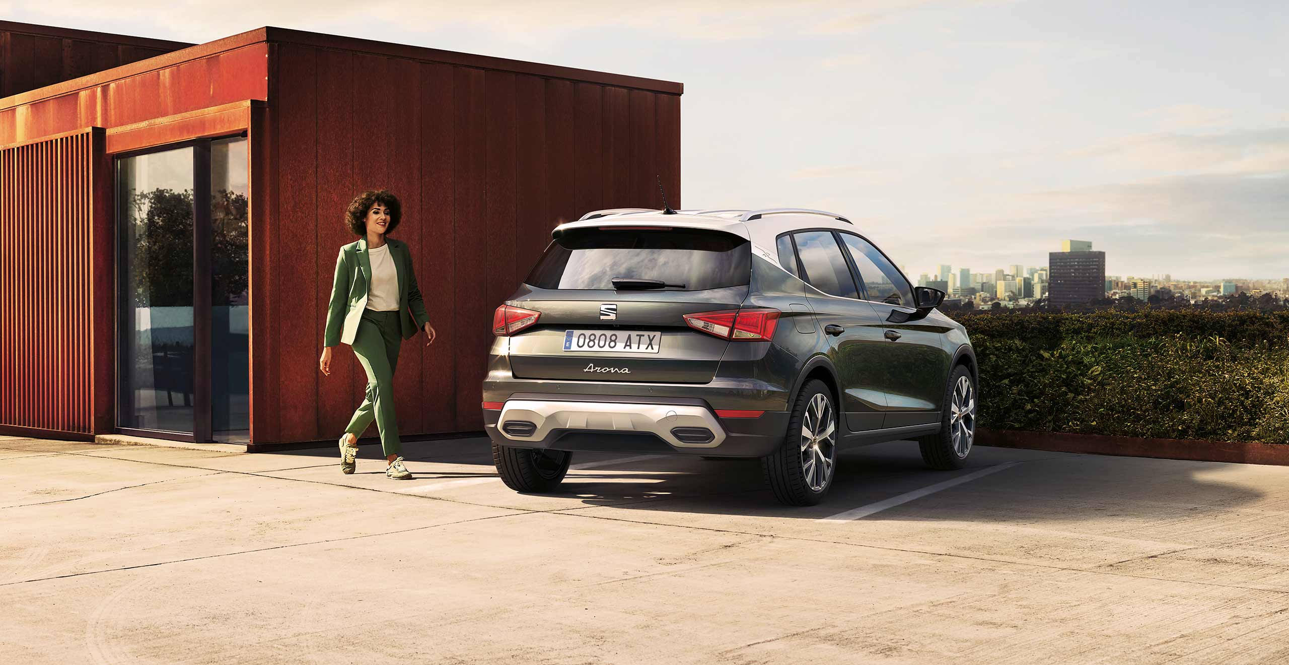 Business woman walking toward a SEAT Arona 