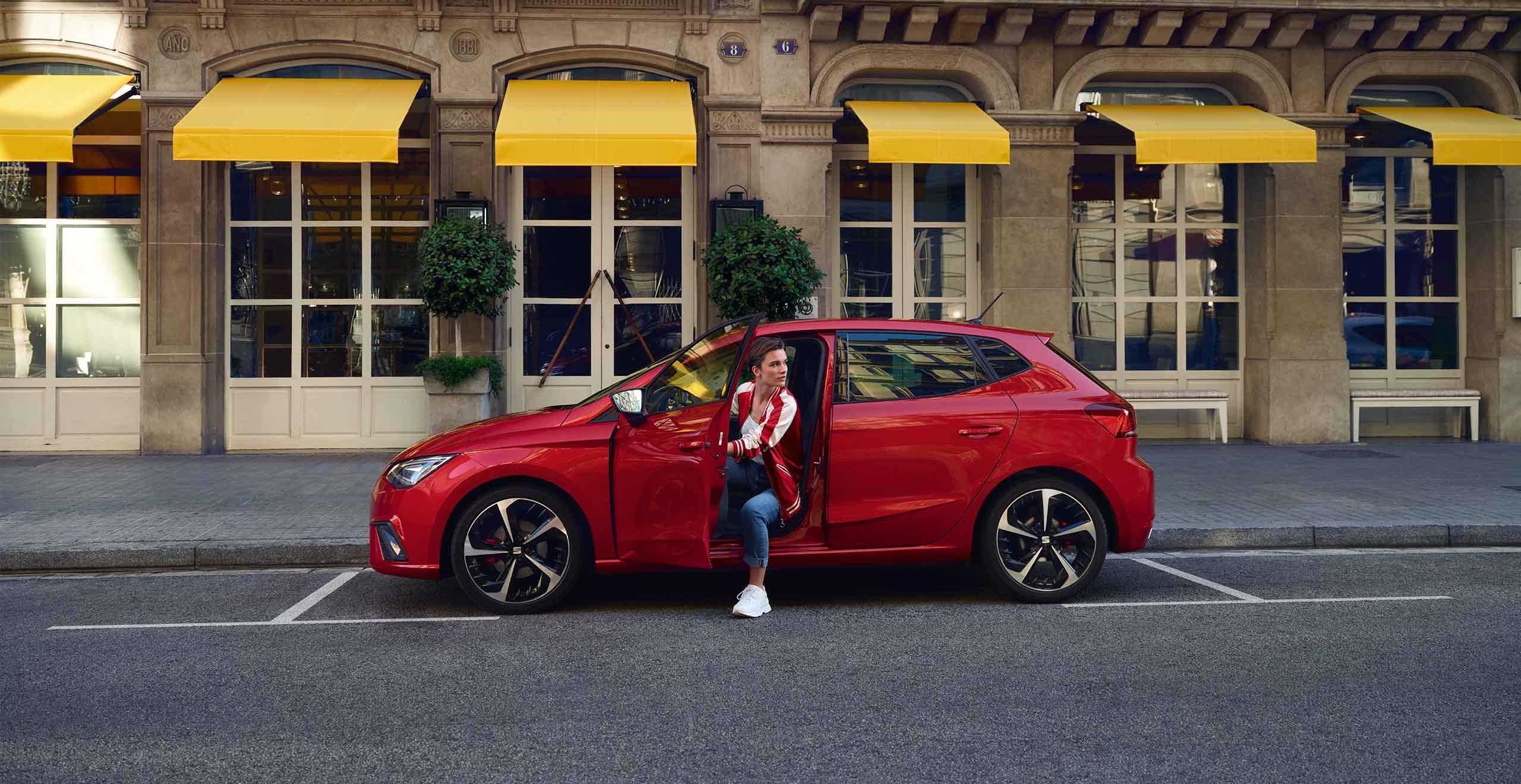 Business woman walking toward a SEAT Arona 