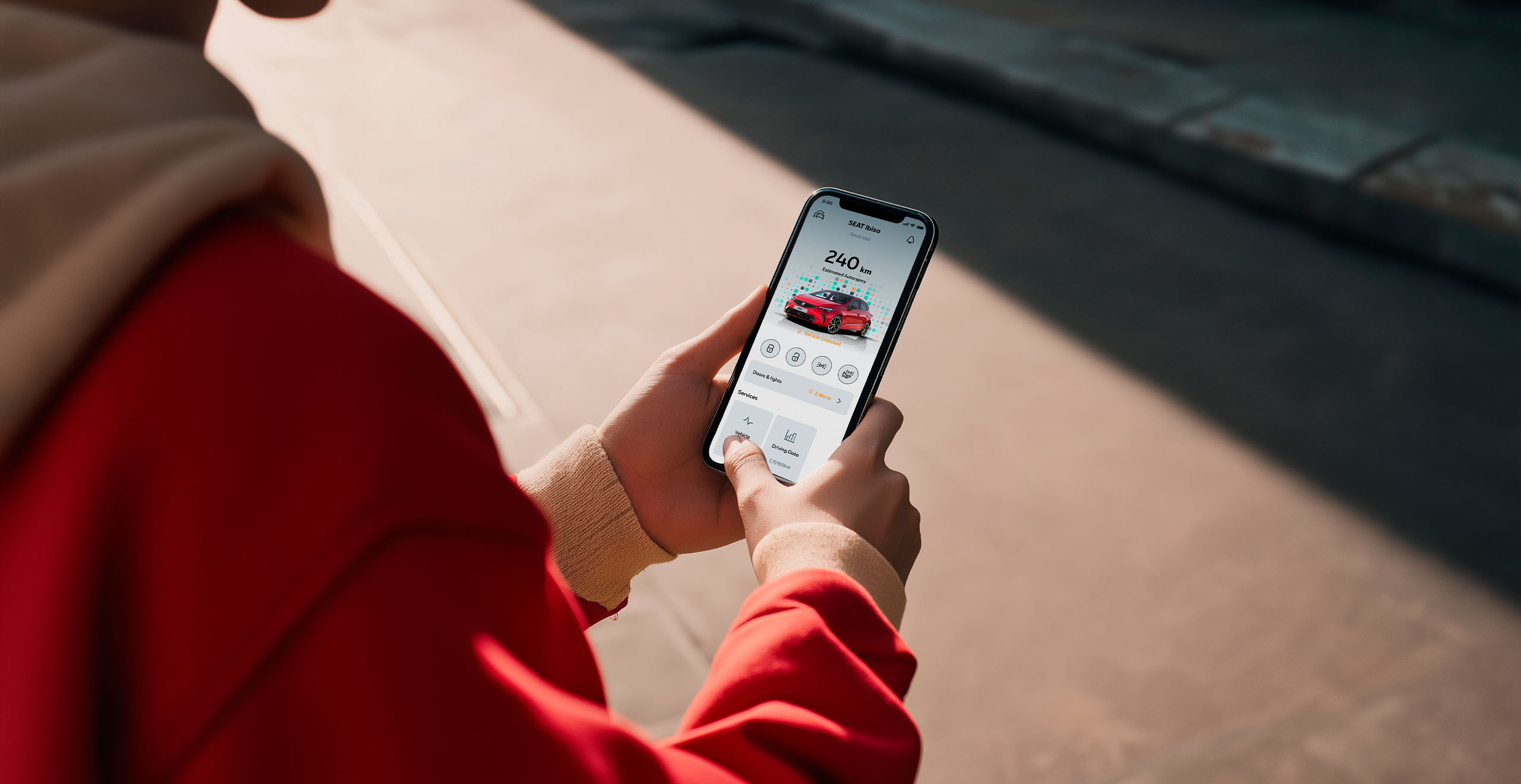 A person using the My SEAT App on their smartphone to remotely access and control their SEAT Ibiza, viewing vehicle status and connectivity options, highlighting SEAT’s innovative connected car technology and effortless digital experience.