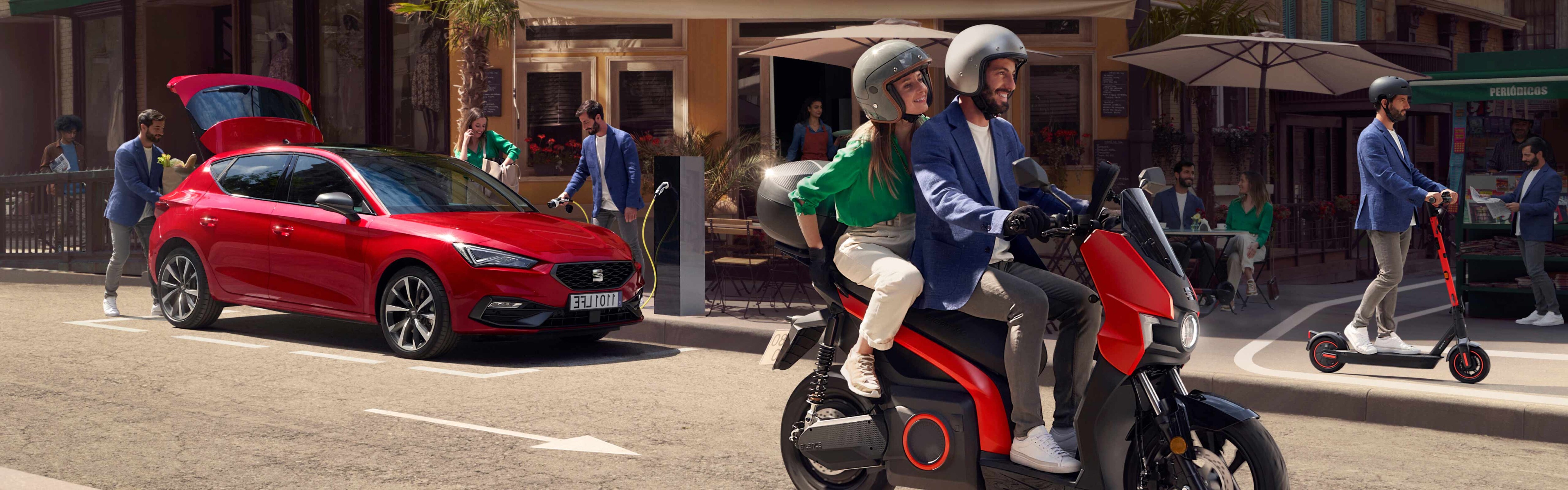 Couple riding the electric SEAT MÓ 125 scooter on city street